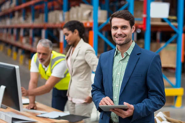 Enfocarse en el gerente está sonriendo y sosteniendo una tableta — Foto de Stock