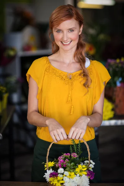 Vrouwelijke bloemist holding mand van bloem — Stockfoto