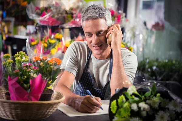 Floristería masculina tomando el orden en el teléfono móvil — Foto de Stock