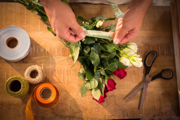 Floristería masculina atando cinta polivinílica en ramo de flores — Foto de Stock