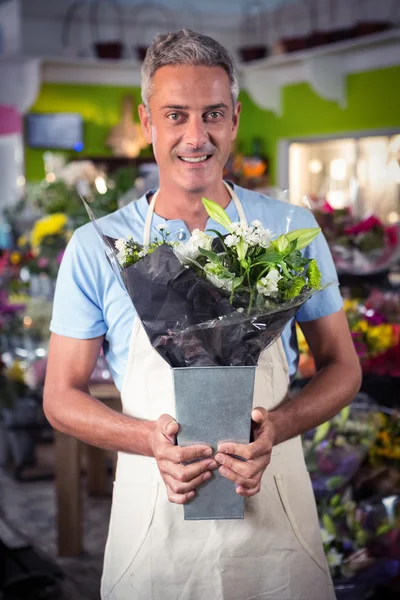 Mannelijke bloemist houden boeket van bloem op bloemenwinkel — Stockfoto