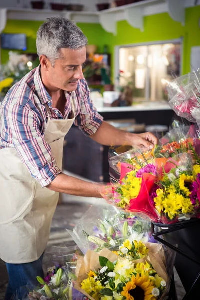 Florista masculino arranjando buquê de flor — Fotografia de Stock