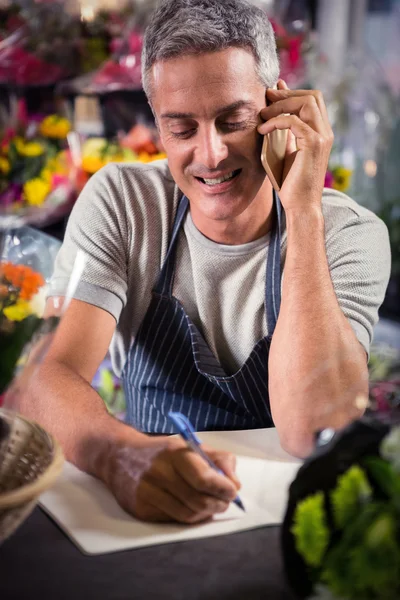 Florista masculino tomando ordem no telefone móvel — Fotografia de Stock