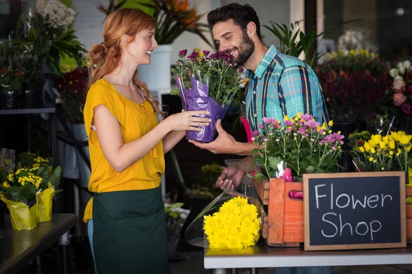 Vrouwelijke bloemist bloemboeket geven man — Stockfoto