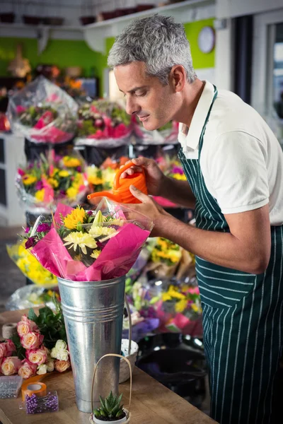 Florista masculino regando flores com regador de lata — Fotografia de Stock