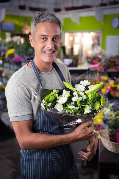 Mannlig blomsterhandler som holder en haug med hvite blomster i vase – stockfoto