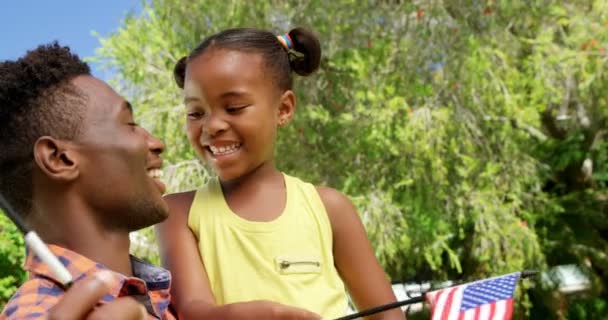 Hombre sosteniendo hija y bandera americana — Vídeos de Stock