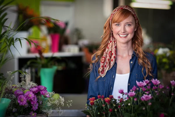 Щасливий жіночий флорист у квітковому магазині — стокове фото