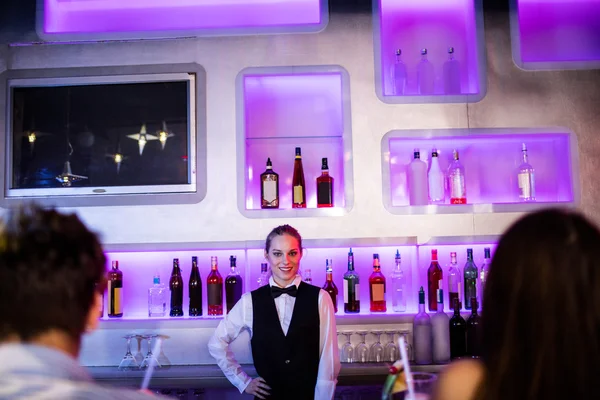 Barmaid in piedi con mano sul fianco sul bancone del bar — Foto Stock