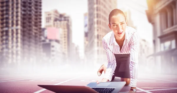 Mujer de negocios de rodillas sosteniendo portátil — Foto de Stock