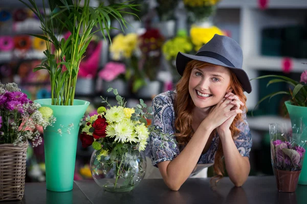 Glückliche Blumenhändlerin lehnt in Blumenladen — Stockfoto