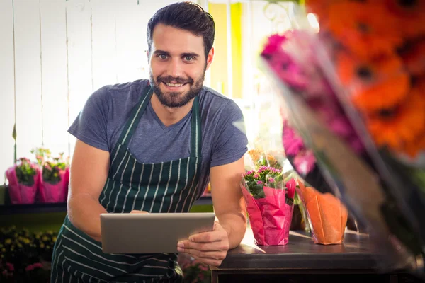 Floristería masculina sosteniendo tableta digital en su tienda de flores —  Fotos de Stock