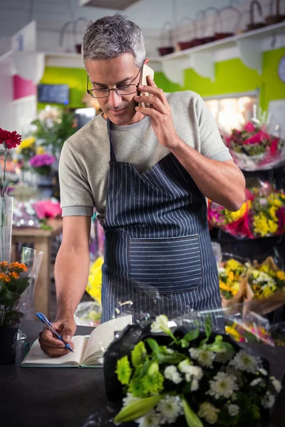 Vesz rend a mobiltelefon férfi virágüzlet — Stock Fotó