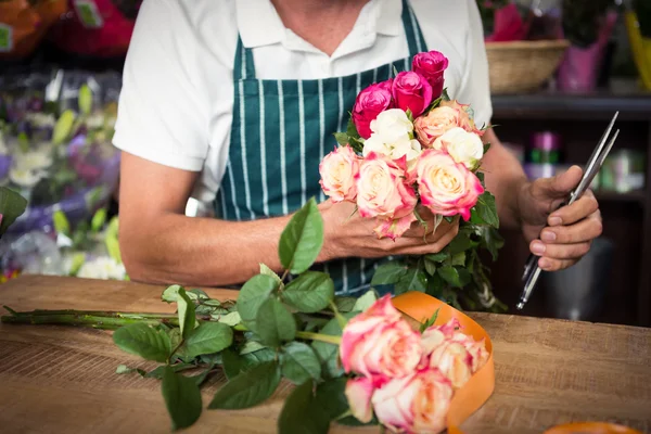 Floristería masculina sosteniendo racimo de rosas y tijeras —  Fotos de Stock