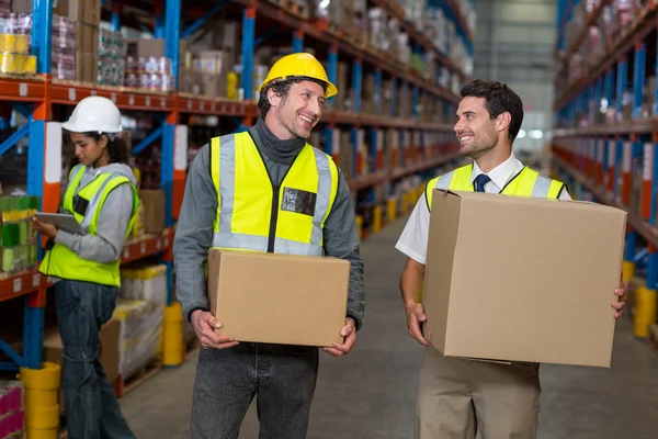Workers holding box looking each other — Stock Photo, Image