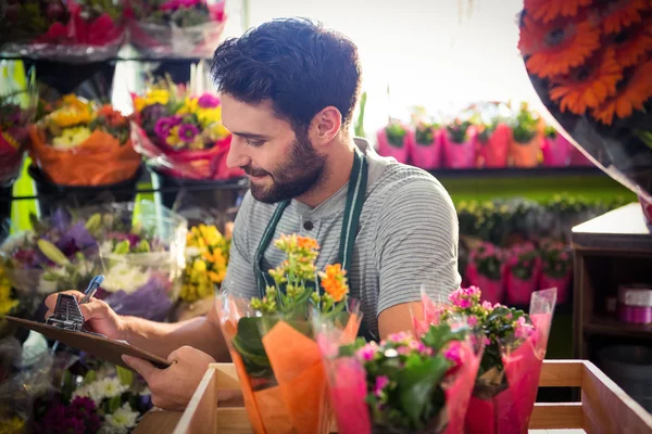 Floristería masculina escribiendo y tomando notas — Foto de Stock