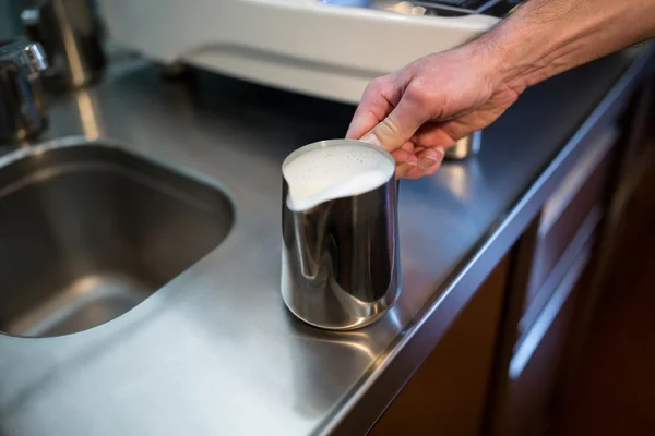 Waiter holding jug of milk — Stock Photo, Image