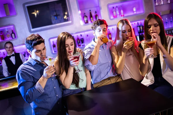 Amigos tomando un cóctel en el mostrador del bar — Foto de Stock