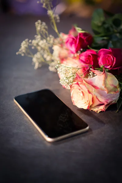Rosas rosadas y smartphone sobre la mesa —  Fotos de Stock