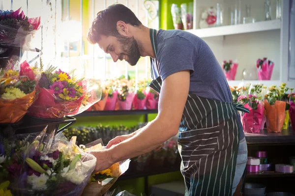 Floristería masculina arreglando ramo de flores en la florería — Foto de Stock