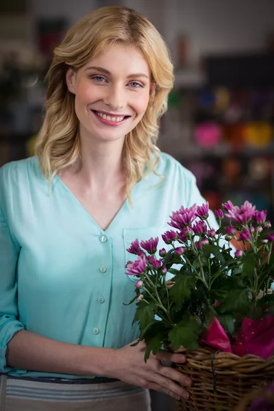 Mutlu kadın çiçekçi çiçek sepeti tutan — Stok fotoğraf