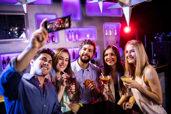 Amigos tomando selfie mientras toman vasos de cóctel — Foto de Stock