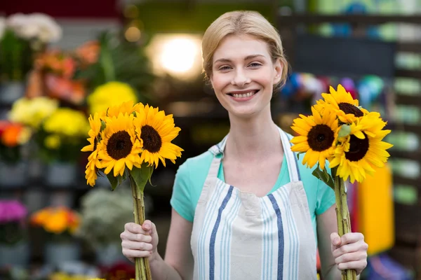 Fleuriste femelle tenant des fleurs dans la boutique de fleurs — Photo