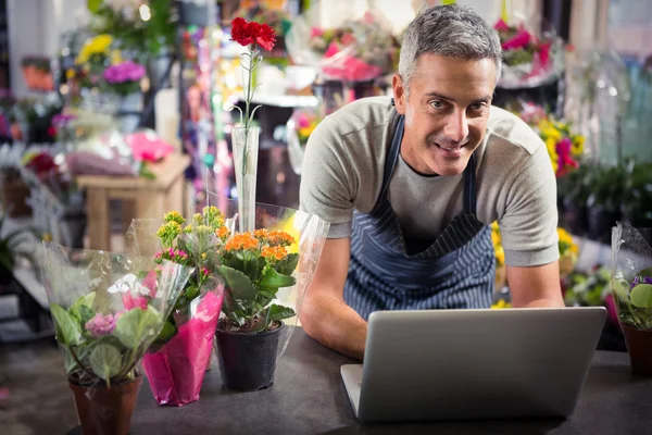 Mannlig blomsterhandler som bruker bærbar datamaskin – stockfoto