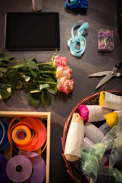 Digitální tabletu a květinářství dodává na dřevěný stůl — Stock fotografie