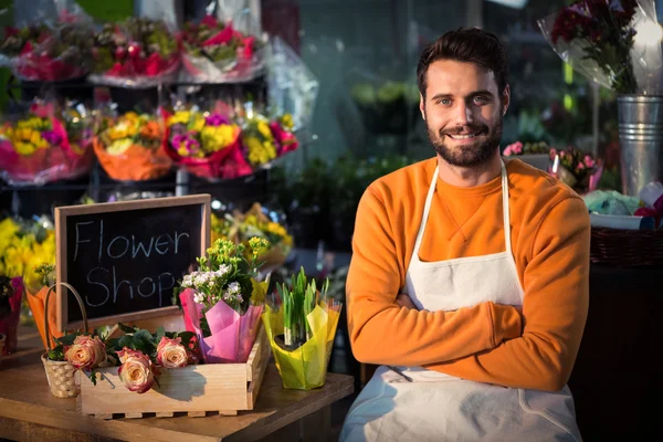 Floristería masculina sentada cerca de mesa — Foto de Stock