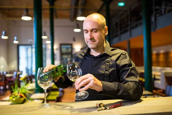 Servitören hälla vitt vin i glaset — Stockfoto