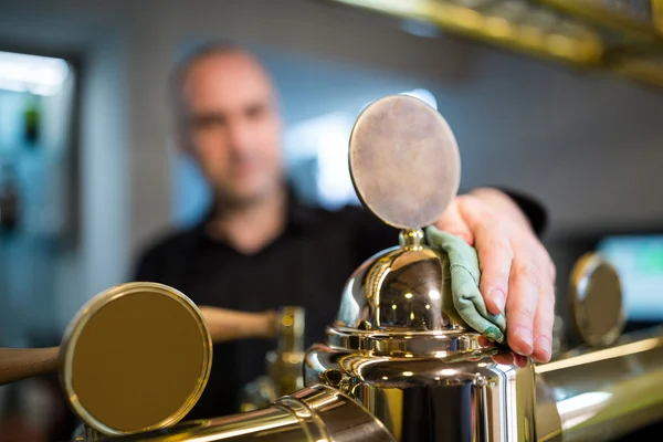 Bar tender cleaning beer pump — Stock Photo, Image