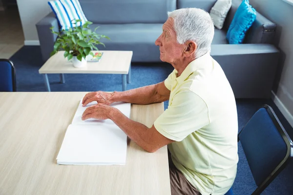 Äldre man med blindskrift att läsa — Stockfoto