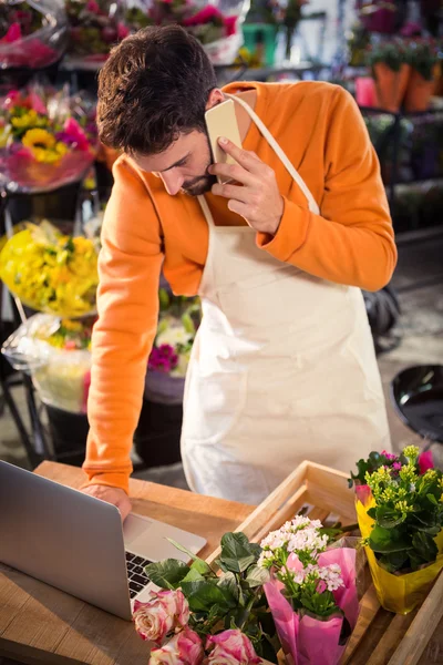 Floristería masculina tomando el orden en el ordenador portátil —  Fotos de Stock