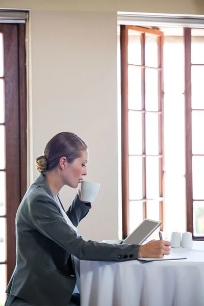 Kvinnan arbetar och dricka en kopp kaffe — Stockfoto