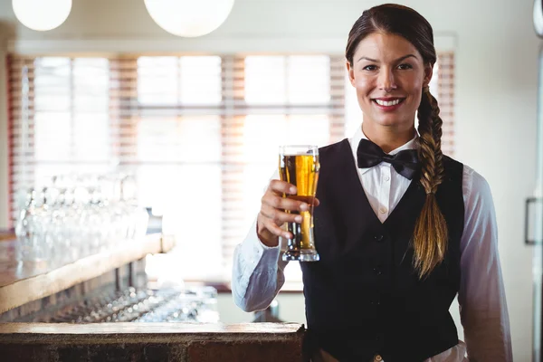 Empregada segurando uma cerveja — Fotografia de Stock