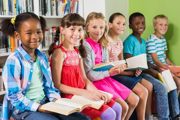Portrait of kids reading book in library — Stock Photo, Image