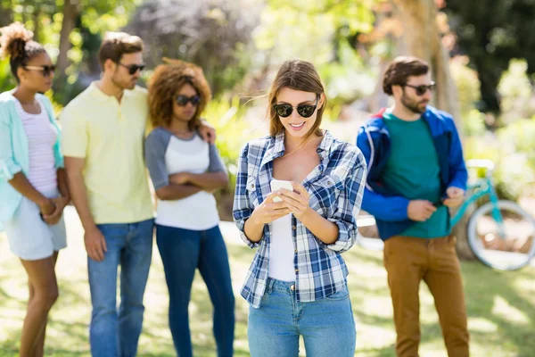 Frau benutzt Handy mit Freunden — Stockfoto