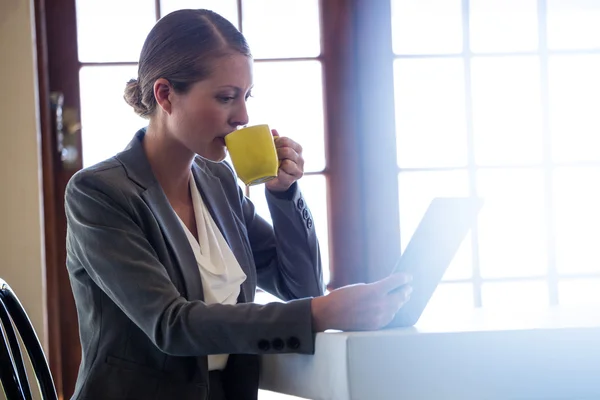 Frau trinkt Kaffee und benutzt Tablette — Stockfoto