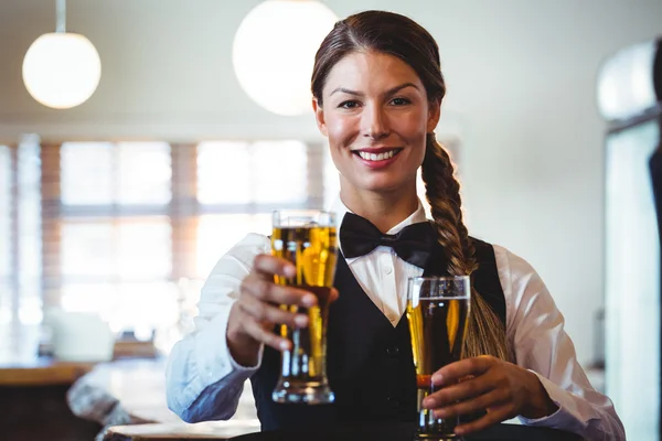 Empregada segurando cervejas — Fotografia de Stock