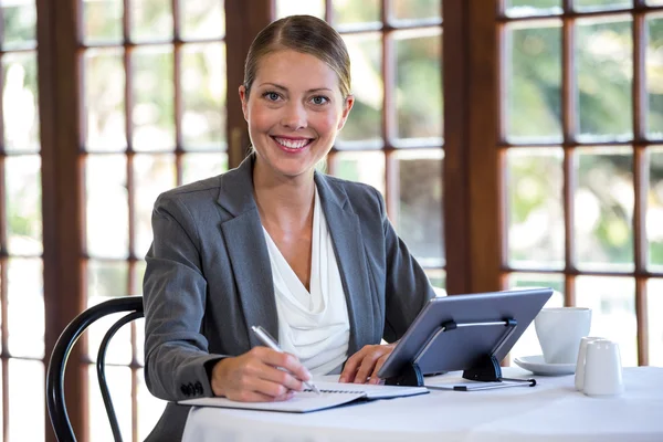 Frau schreibt in Notizbuch — Stockfoto