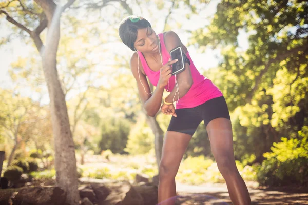 Mujer deportiva tocando su teléfono móvil —  Fotos de Stock