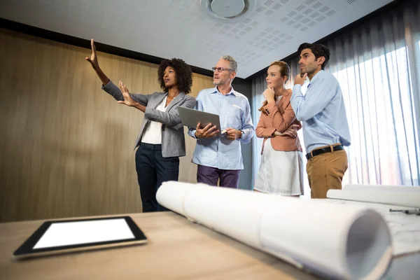 Woman framing with hand while standing in board room — Stock Photo, Image