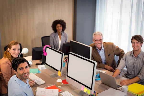 Empresários sorridentes sentados no cargo — Fotografia de Stock