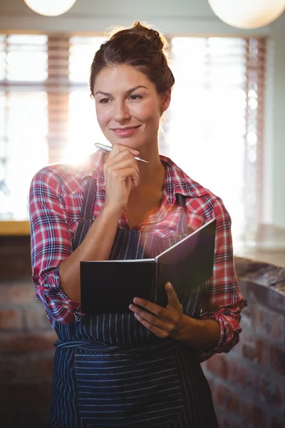 Waitress holding a pen and a book — Stock Photo, Image