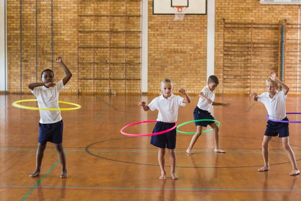 Studenti s hula hoop ve školní tělocvičně — Stock fotografie