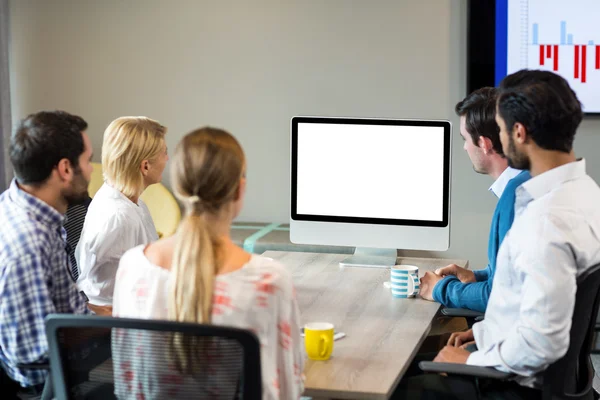 Geschäftsleute schauen während einer Videokonferenz auf einen Bildschirm — Stockfoto