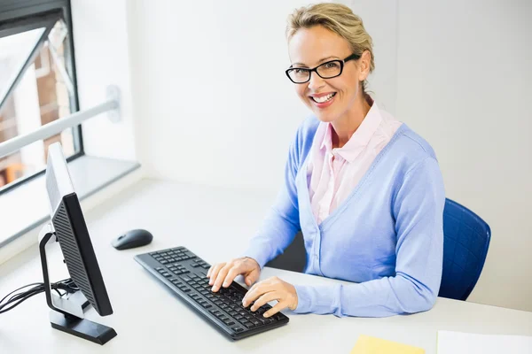 Teacher working on computer in classroom — Stock Photo, Image
