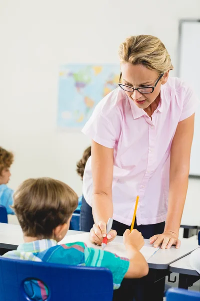 Profesor ayudando a los niños con su tarea en el aula — Foto de Stock