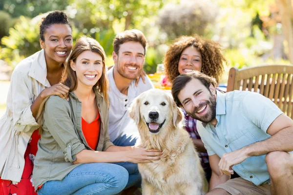 Amigos sentados junto con el perro —  Fotos de Stock